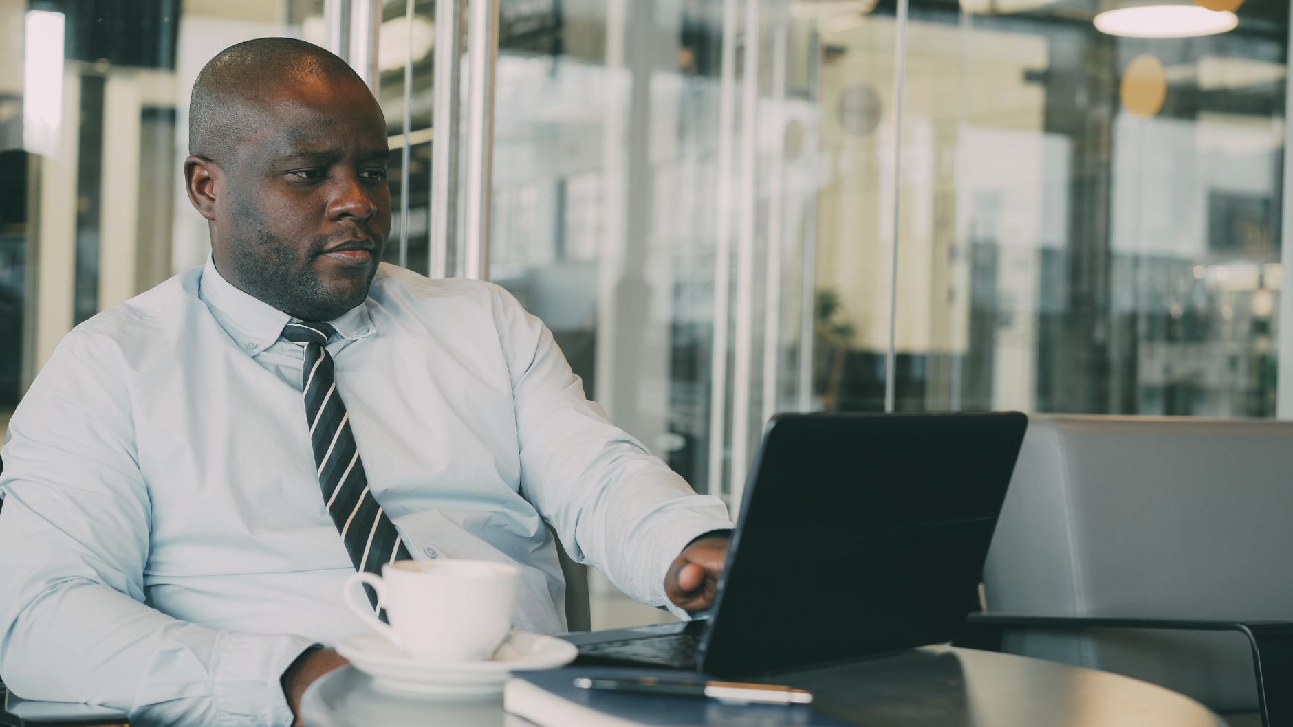 Focused businessman uses laptop in stylish cafe, sipping coffee. Perfect for business or lifestyle themes. — How Much Money S