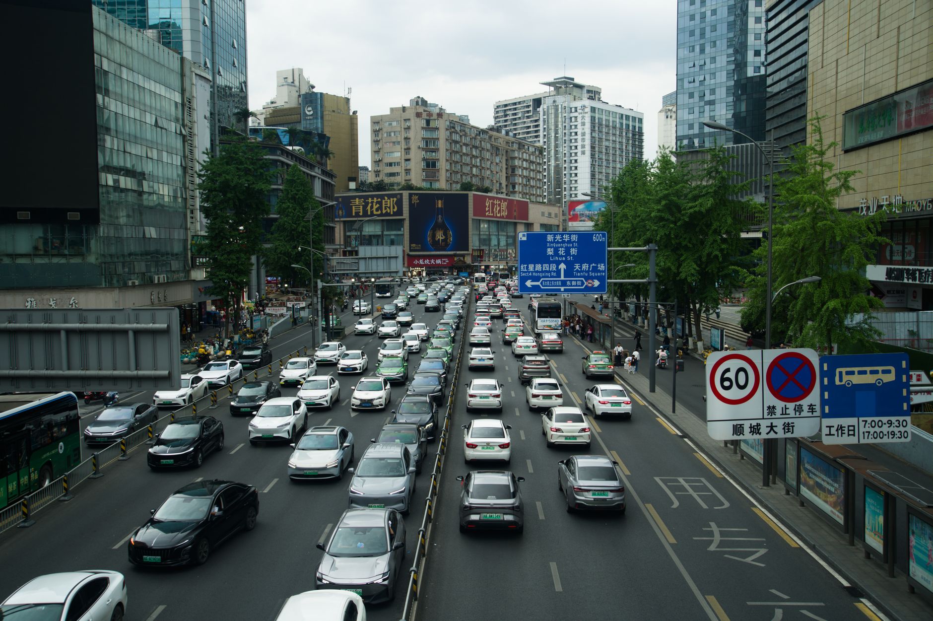 Heavy traffic on a busy Shanghai street lined with skyscrapers and billboards during the day. — Recycle PET and Preserve Mate