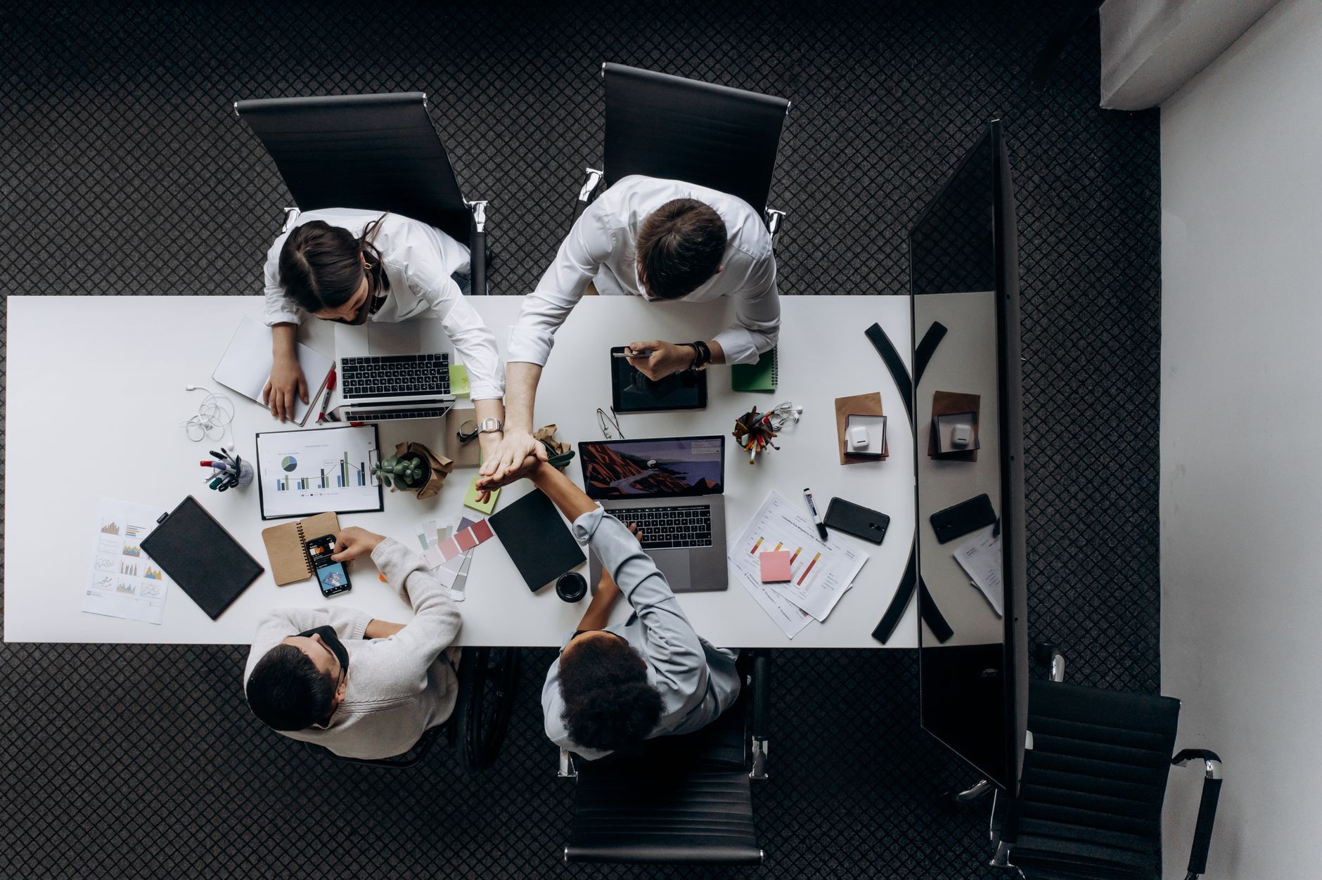 High angle view of colleagues collaborating around a conference table in a modern office setting. — "The Ripple Effect: How J