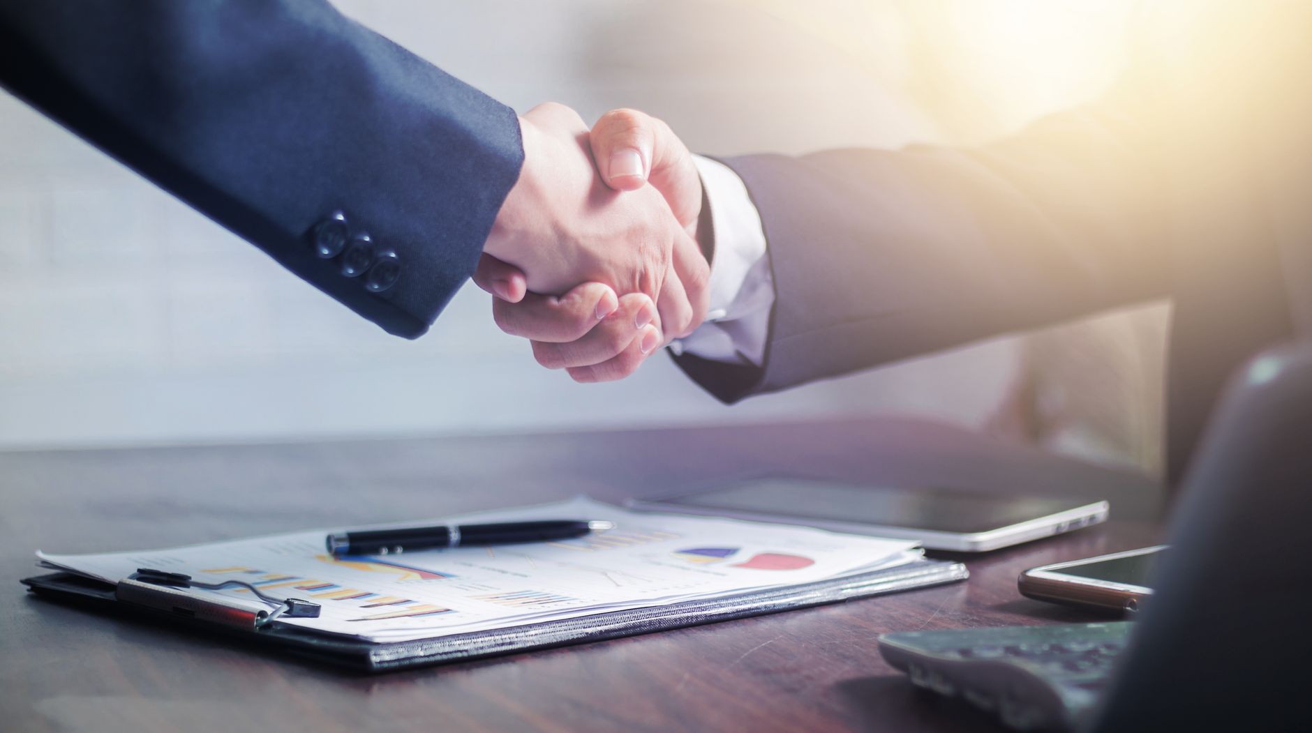 Professional handshake agreement over business charts in an office setting. — What determines the legality of an official doc